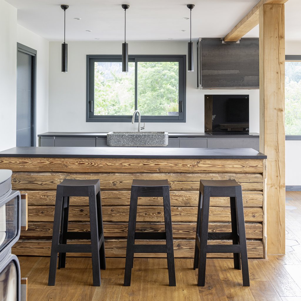 Tabouret en frêne laqué intégral sur mesure en noir intense devant un bar